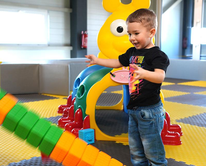 Kleines Kind spielt mit bunten Bausteinen im Kleinkindbereich